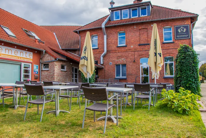 Sitzplätze im Garten vor der Backsteinfassade des Gasthauses