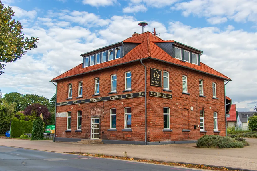 Gasthaus Kronenhof — dreigeschossiger Backsteinbau mit rotem Ziegeldach und dem Kronenhof-Schild