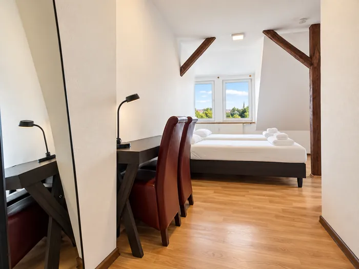 Schreibtisch und Betten im Dachgeschoss