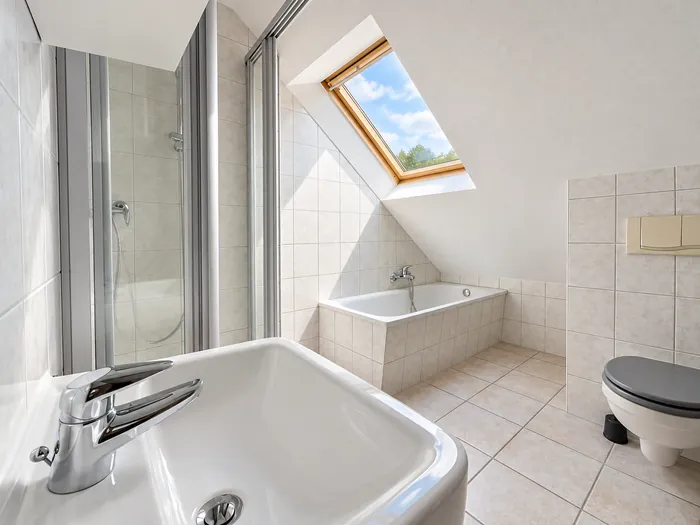 Bad unterm Dach mit Badewanne, Dusche und Dachfenster